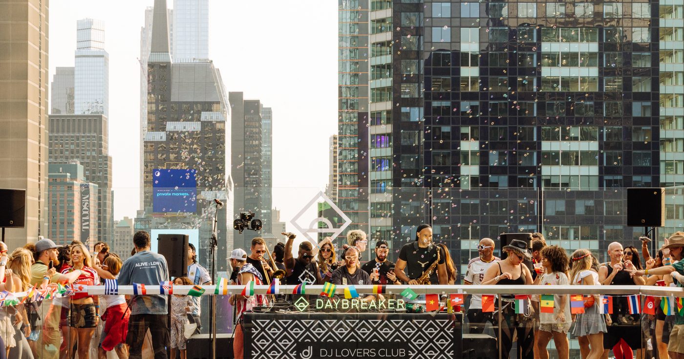 The DJLC and Daybreaker sunrise crowd dancing on the One Times Square rooftop deck above Times Square