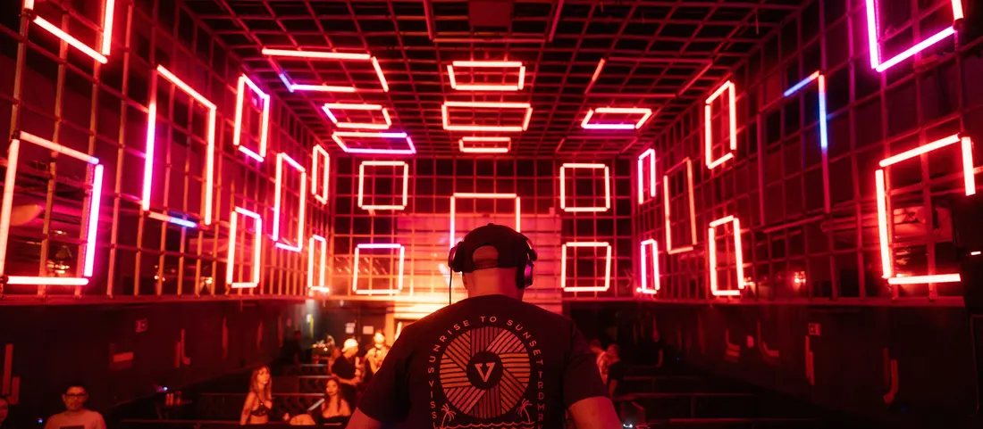 A club room glowing red under LED frames