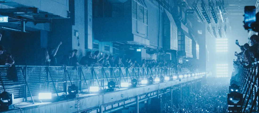The crowd moving through an industrial venue hall