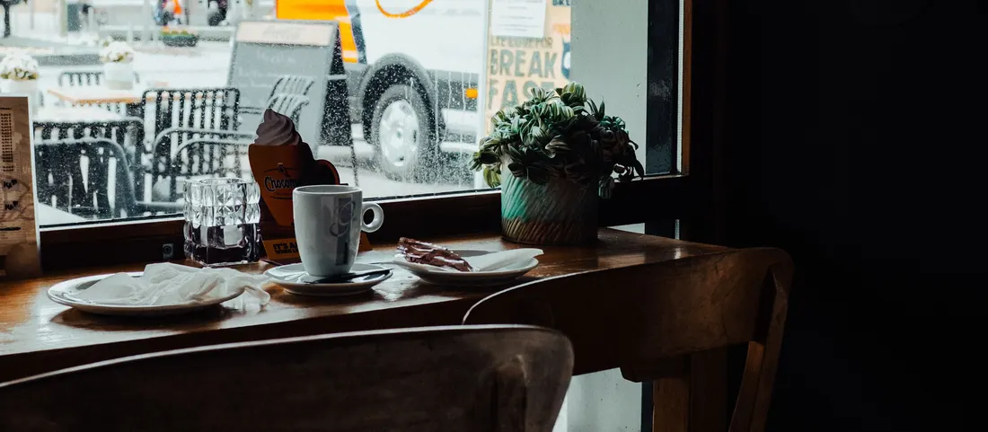 A quiet bakery table by the window on a grey morning