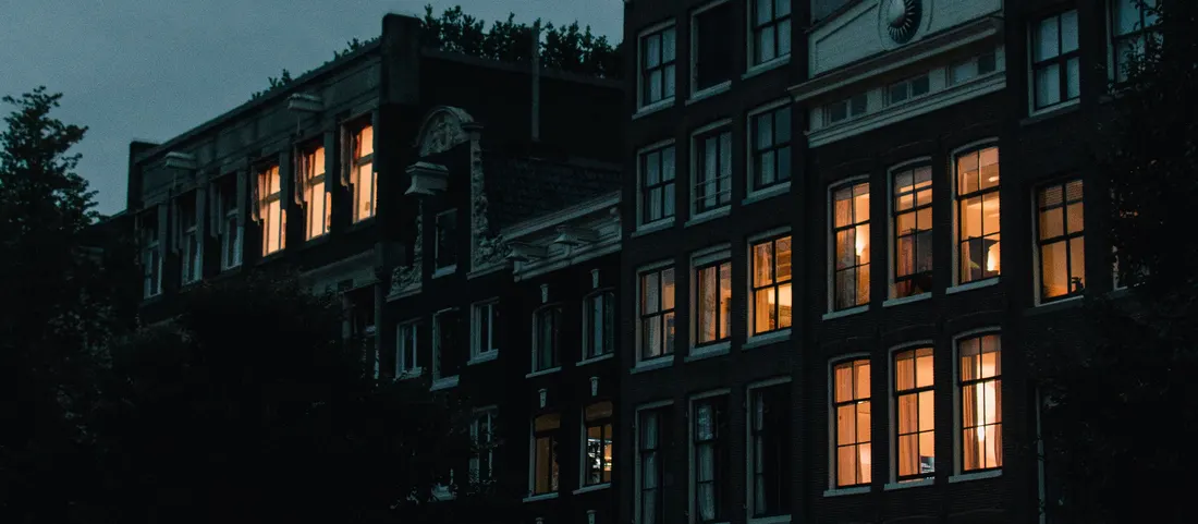 A dark canal street with houses and parked bikes