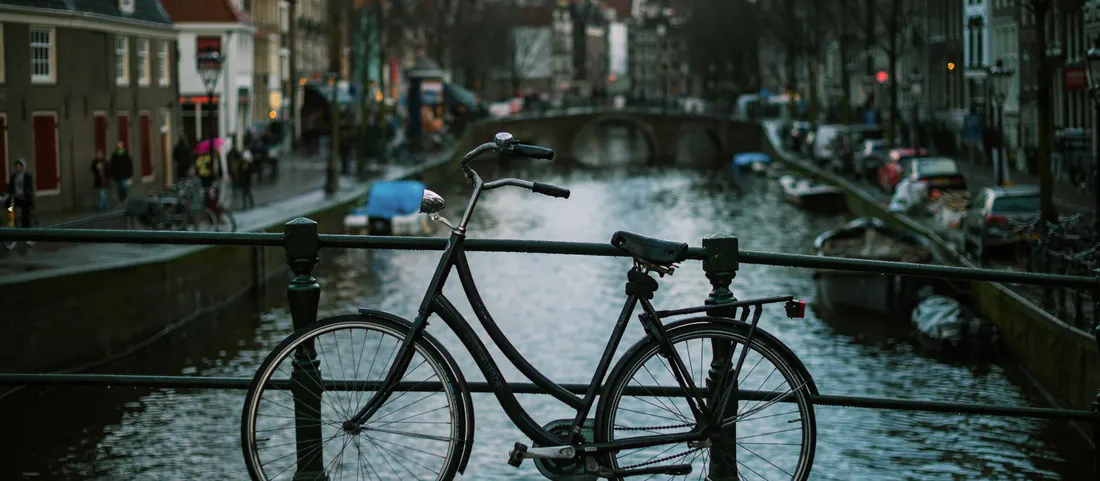 A bike leaning on a canal bridge rail